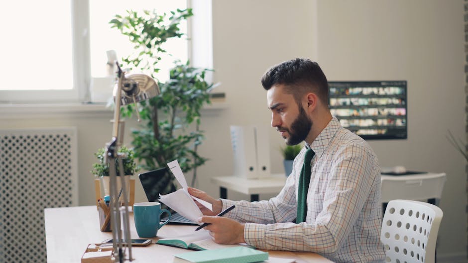 Malaysian professional reviewing course material at their office desk